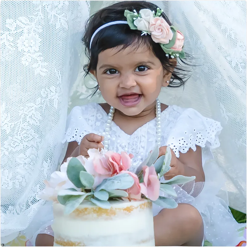 Baby in white dress and cake